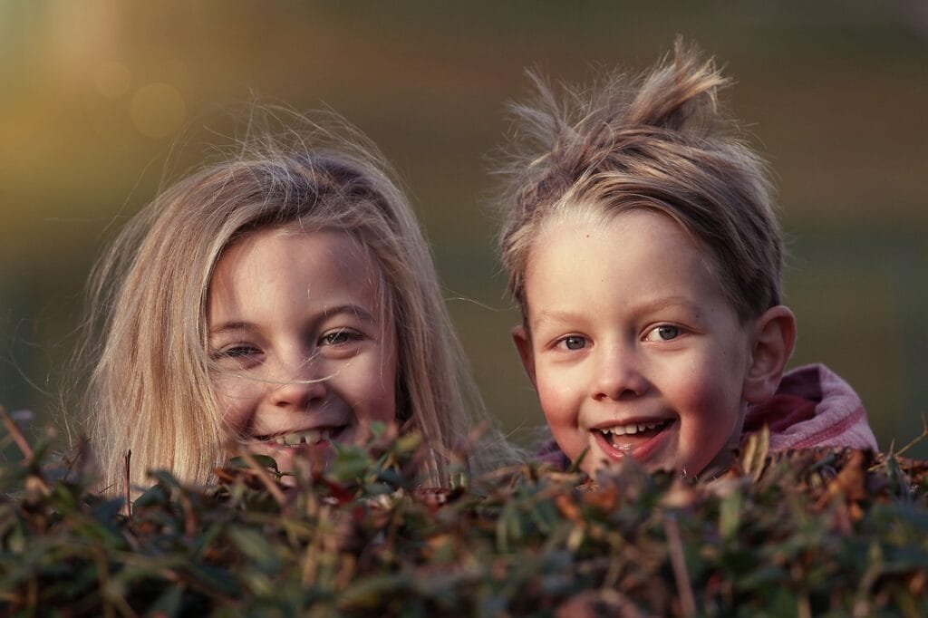 Signs of grooming in children can often be mistaken for normal adult/child interactions - two happy children smiling